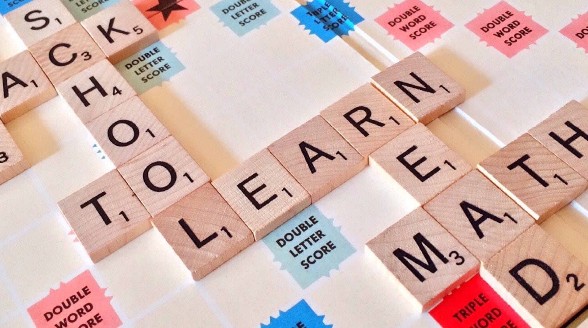 Close-up of Scrabble tiles forming words related to education and school.